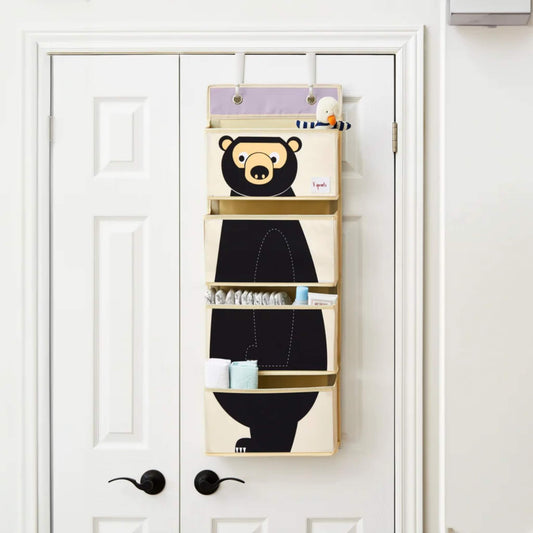 3 Sprouts hanging organiser in use on a white door, neatly holding baby changing supplies in its four spacious pockets.