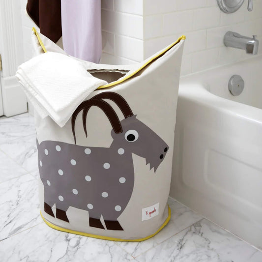 Goat laundry hamper placed beside a bathtub, partially filled with towels. Shows practical size and bathroom setting for context.