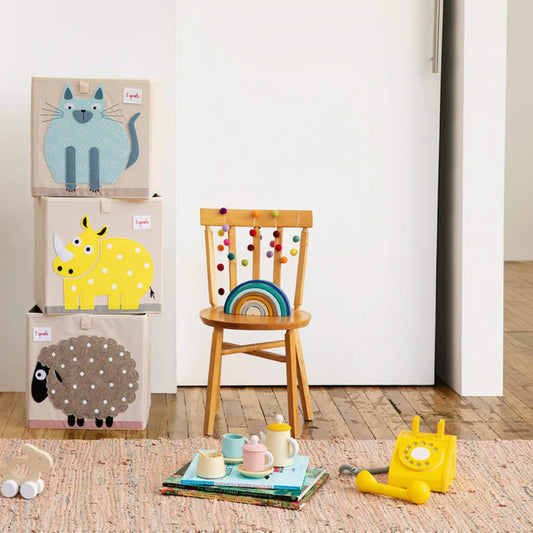 Blue Cat Storage Box stacked with yellow Rhino and brown Sheep boxes in a colourful playroom setting beside a wooden chair and toys.