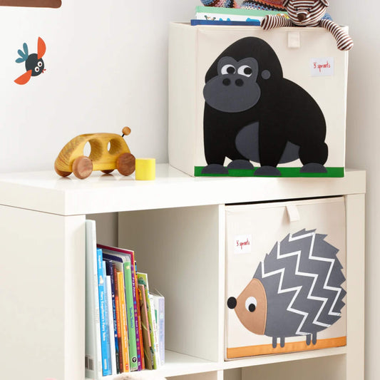 Gorilla storage box on top of a white cubby unit, styled with a wooden toy car and hedgehog box below in a child's reading nook.