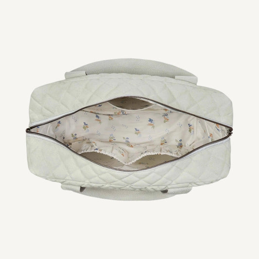 Top view of an open quilted sage green baby changing bag showing spacious interior with patterned lining and elasticated organiser pockets.