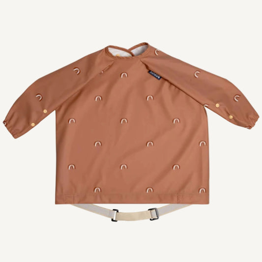 Long sleeve brown coverall bib with small rainbow print, elasticated cuffs and adjustable waist strap for full clothing protection during mealtimes.