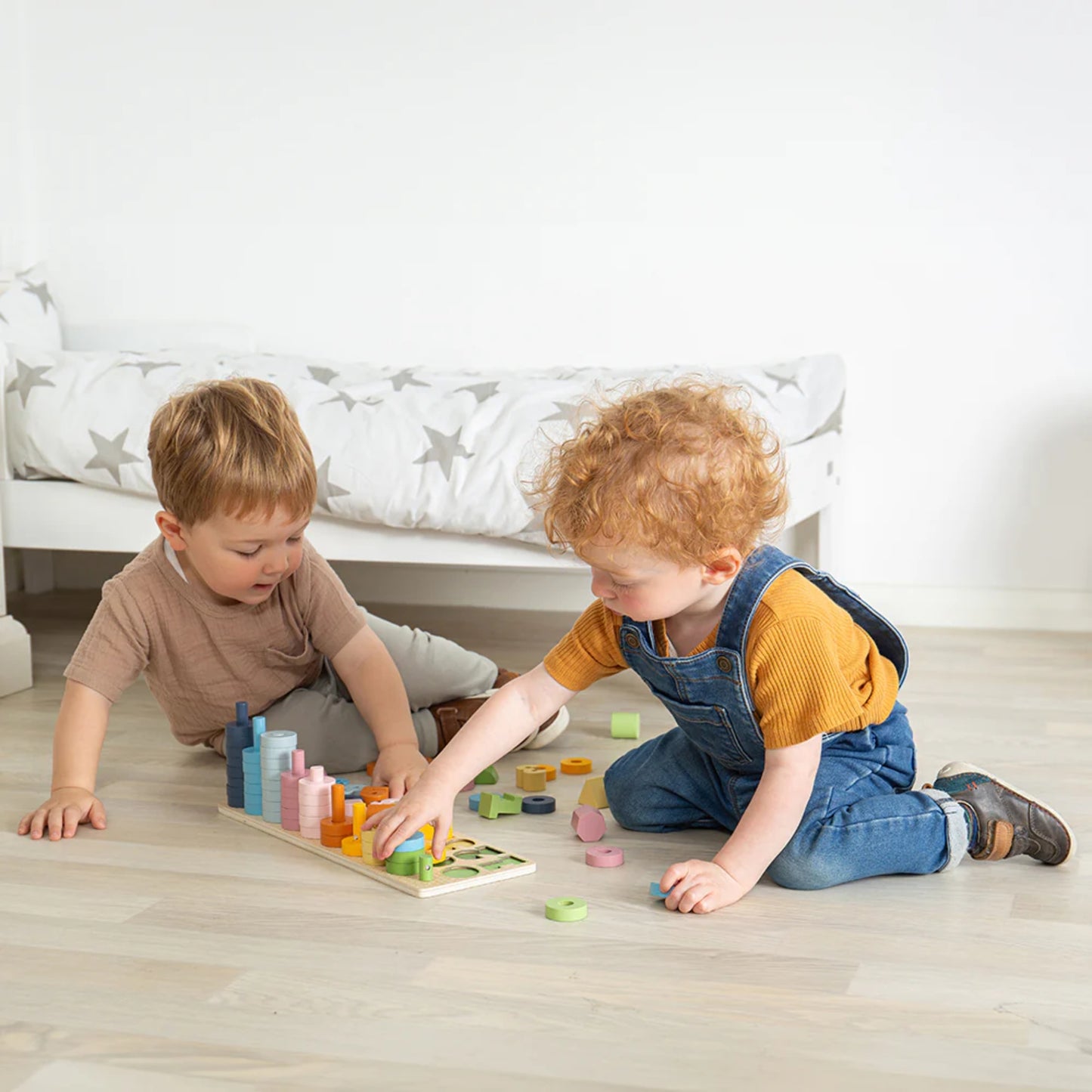Two children playing with the Bigjigs Toys 1-10 Counting Board – Colourful wooden stacking toy for learning numbers and shapes.