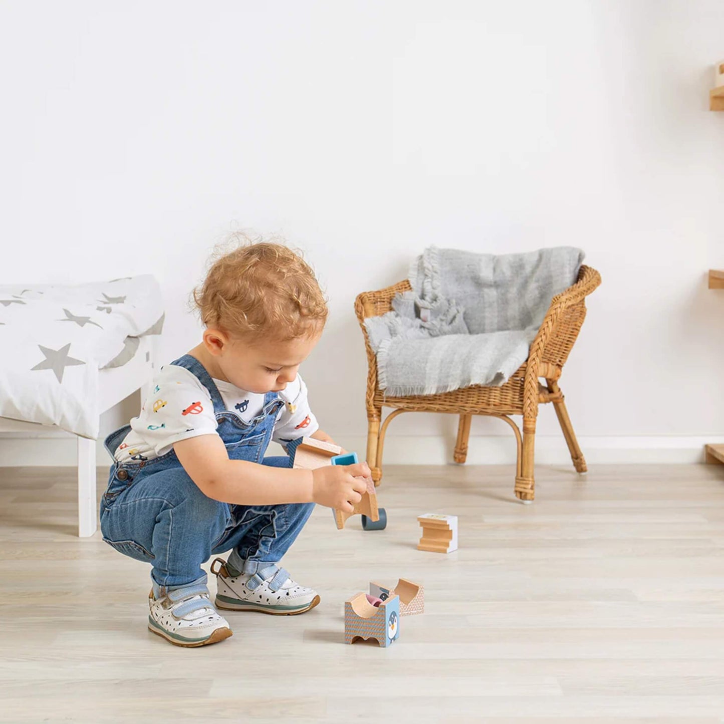 Child squatting to pick up Arctic-themed blocks, exploring balance and coordination during free play.