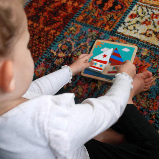 A toddler carefully placing chunky boat puzzle pieces on a sturdy wooden base, exploring shapes and colours.