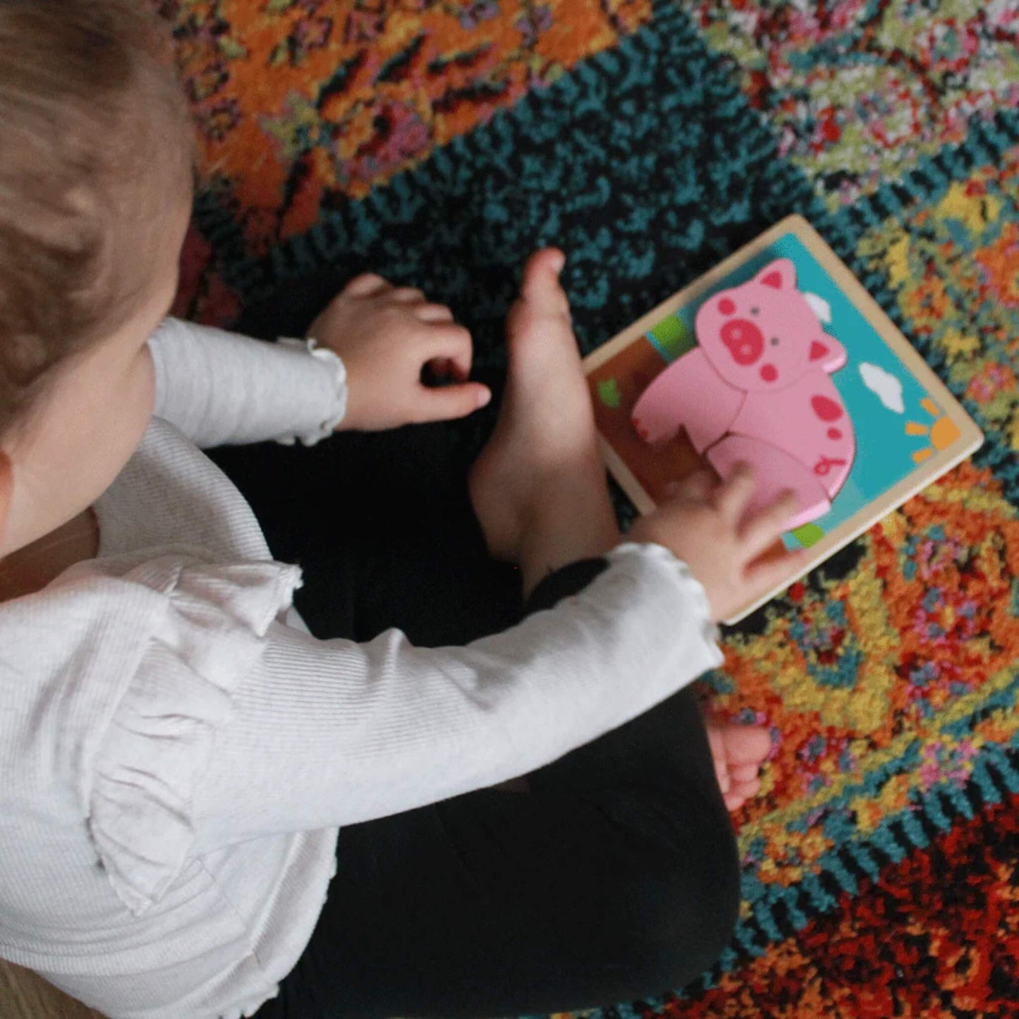 A toddler carefully placing chunky boat puzzle pieces on a sturdy wooden base, exploring shapes and colours.