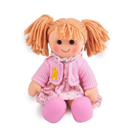 Seated view of Ella Doll showing her soft knitted cardigan, frilly collar, and pale pink dress with delicate garden-themed illustrations.