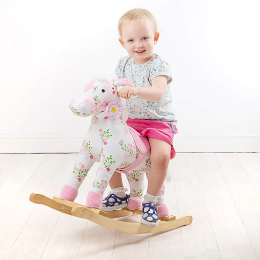A smiling toddler rides the Bigjigs Rocking Horse, showing its child-sized proportions, sturdy wooden frame and easy-grip handles.