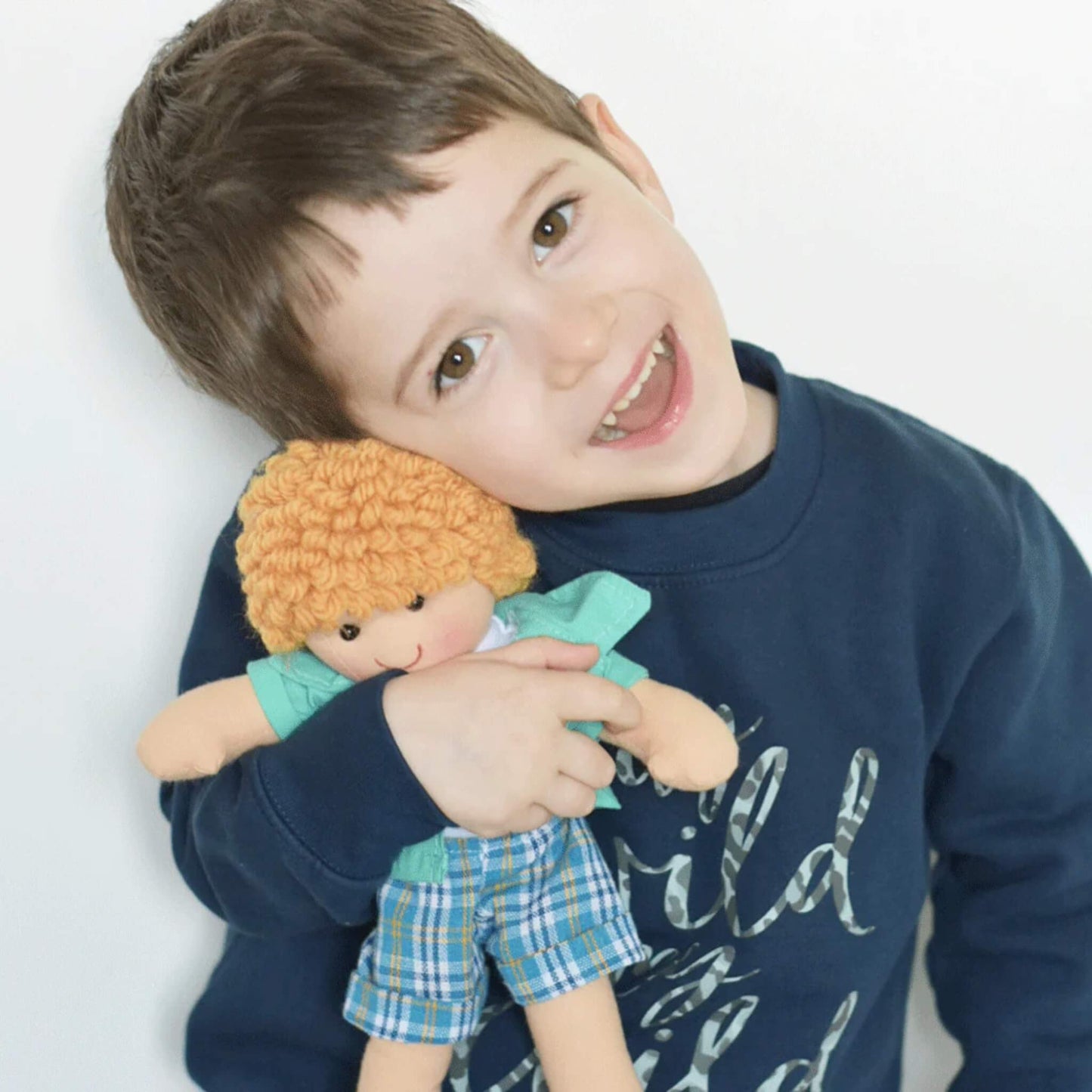 Smiling child hugging the Jacob Doll, showing the doll’s scale and cuddly design in use.