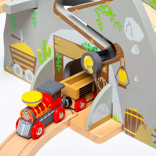 Close-up of the gold mine mountain tunnel in the Bigjigs Toys Wild West Train Set with a red and yellow engine exiting and a moving nugget roller feature above.