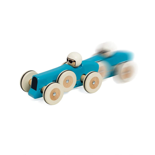 Blue wooden Montlhéry toy race car captured in motion with blur effect, showing the toy speeding forward.
