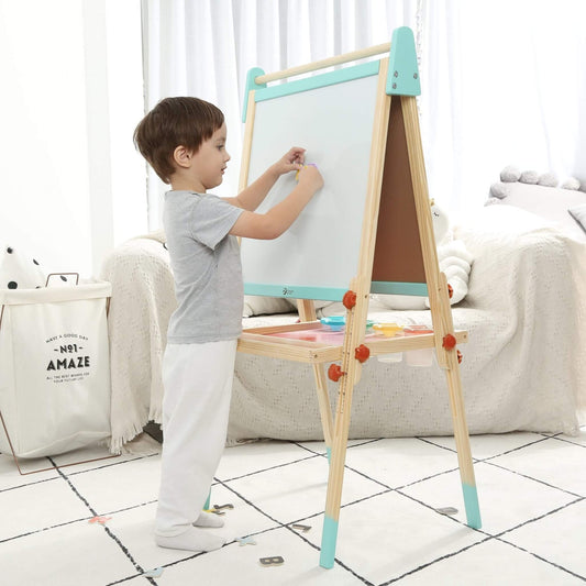 Child using wooden standing art easel with whiteboard surface and paint tray, encouraging drawing, painting and early learning through creative play.
