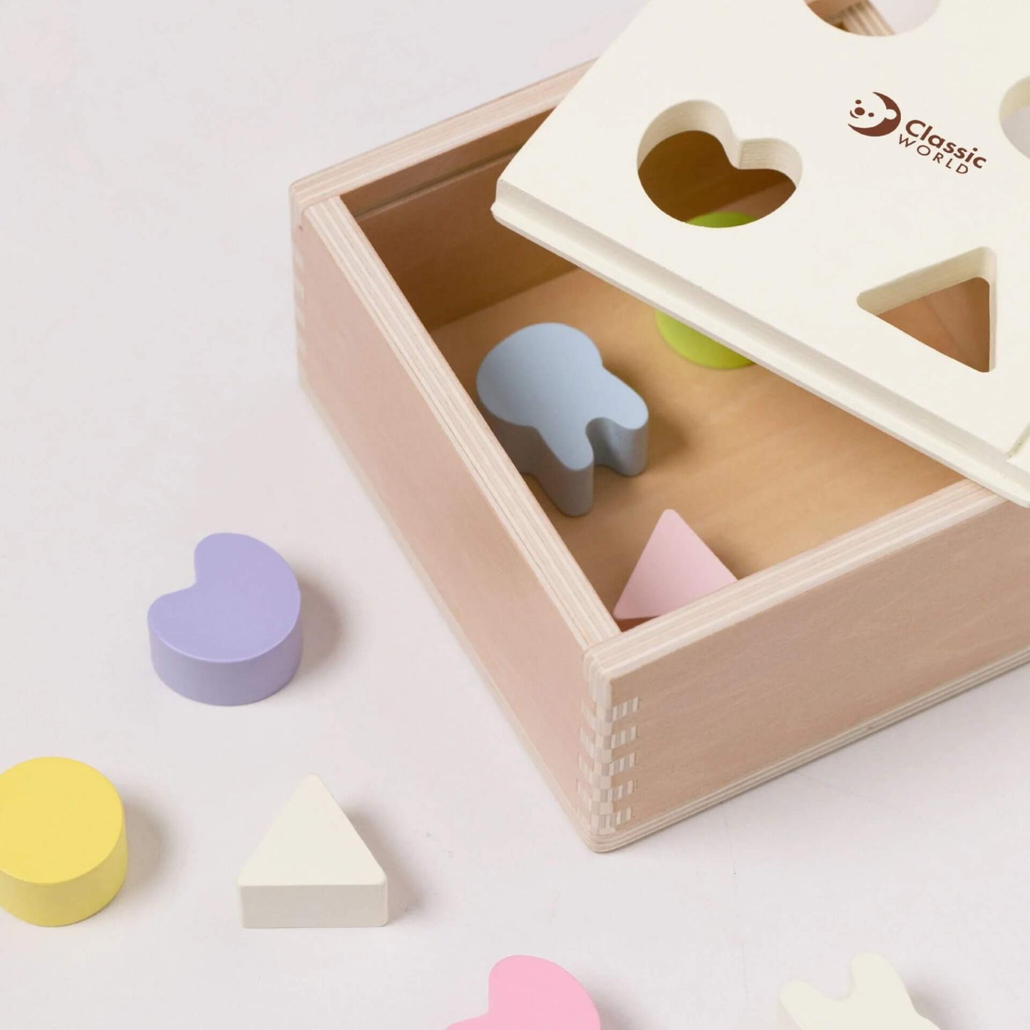 A close-up of the Classic World Mara Shape Sorter showing pastel wooden shapes.