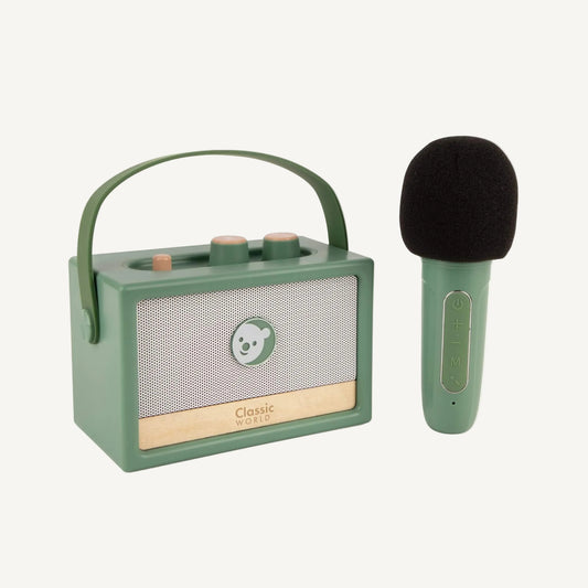 Green toy speaker with carry handle alongside a child-sized microphone, showing portable design for play on the go.