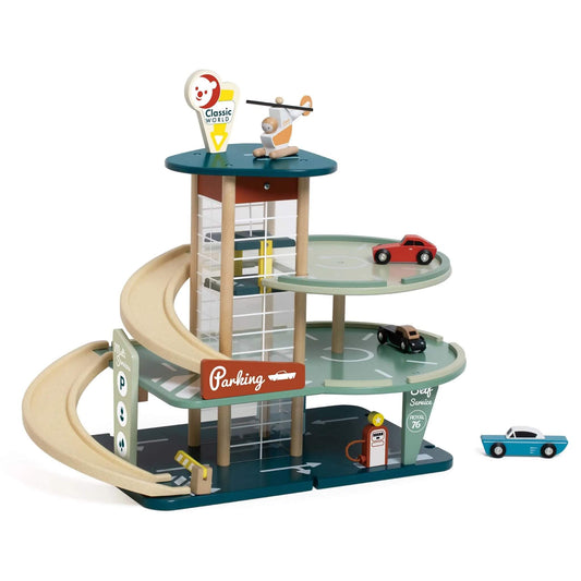 Side view of a vintage-inspired wooden toy garage with spiral ramp, rooftop helipad, toy cars, elevator, and fuel pump on a dark base.