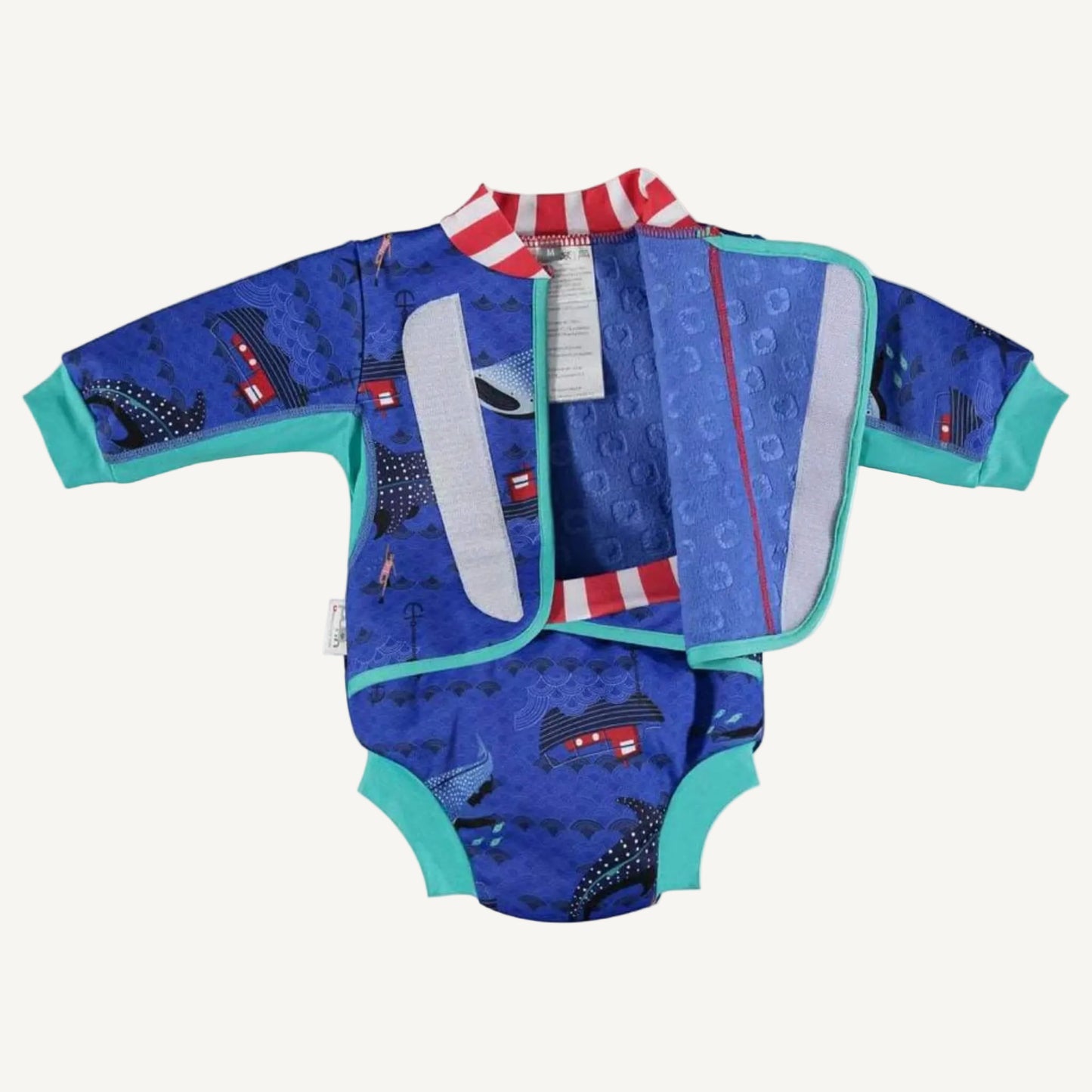 A baby cosy suit opened to show the inner lining, front fastening panels and teal trim alongside the blue whale shark print.