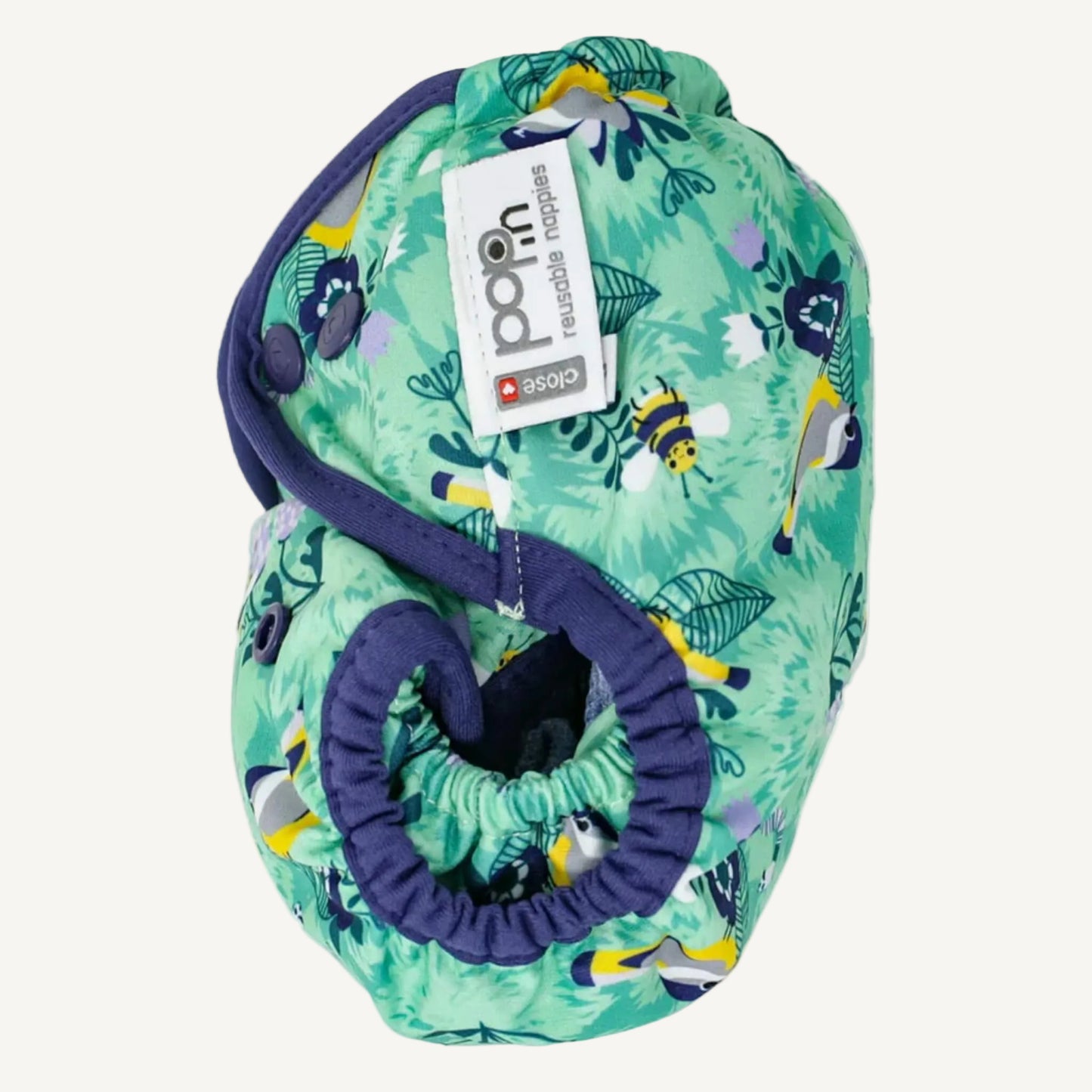 A reusable nappy cover photographed from the side highlighting the gathered leg elastics and shaped opening designed to fit neatly around the legs.
