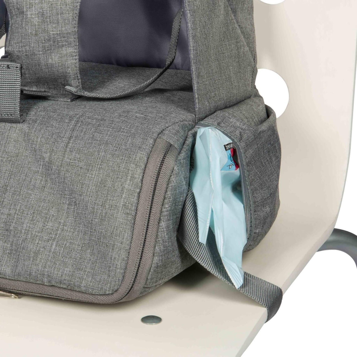 A side compartment of a booster seat showing baby wipes partially pulled through an opening.
