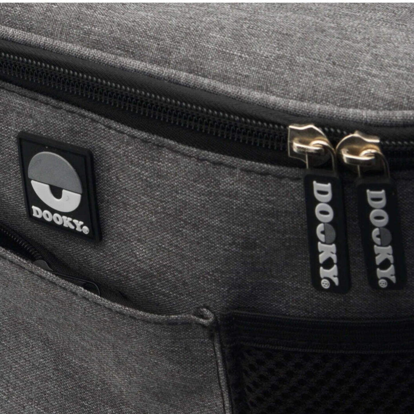 Close-up of grey fabric buggy organiser showing two branded Dooky zip pulls and part of the mesh pocket.