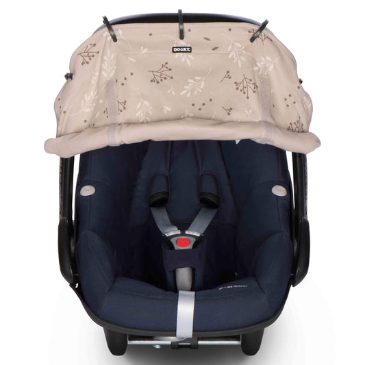A beige sunshade attached to an infant car seat canopy using adjustable rings to provide extra shade on sunny days.