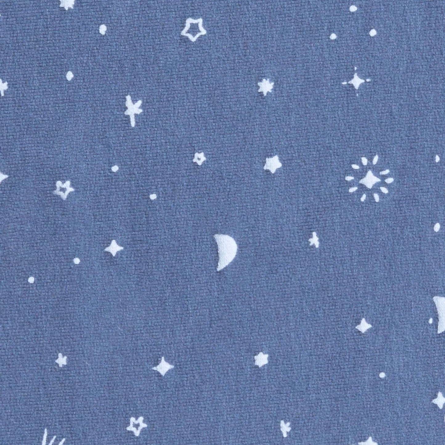 Close-up of blue jersey fabric with scattered white moon, star and comet pattern from the Night Sky babygrow design.