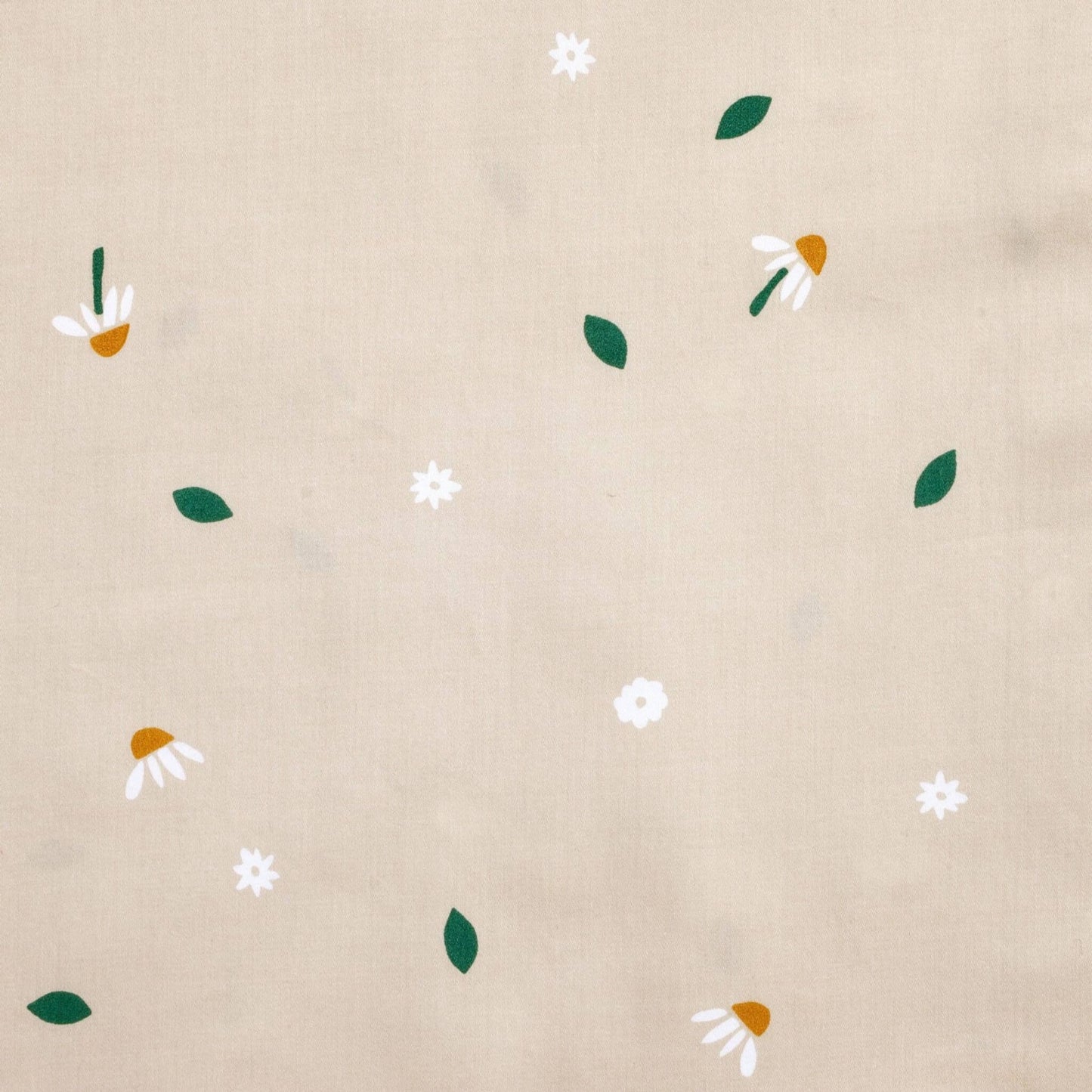 Close-up fabric view of the Daisy Sprinkle fabric print featuring scattered white daisies, golden centres, and green leaves on a beige background.