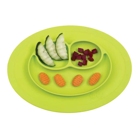 Lime coloured silicone suction placemat with three divided sections containing food including cucumber, beetroot and potato croquettes.