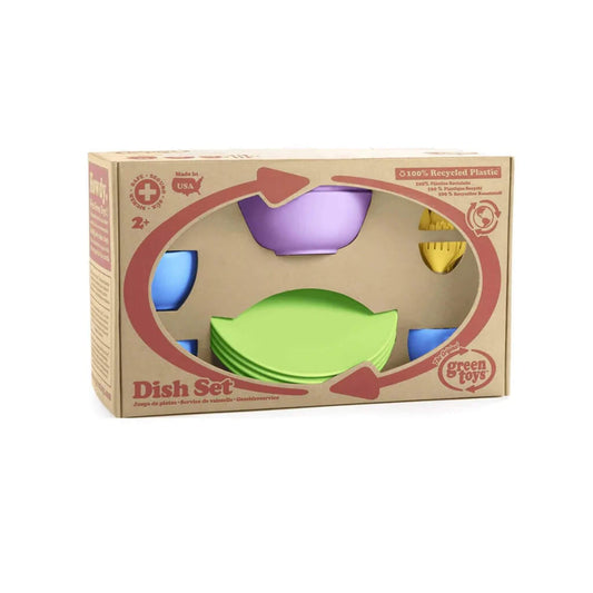 Packaging of the Green Toys Dish Set showing eco-friendly branding and a view of the colourful plates, bowls, cups and cutlery inside the recyclable cardboard box.