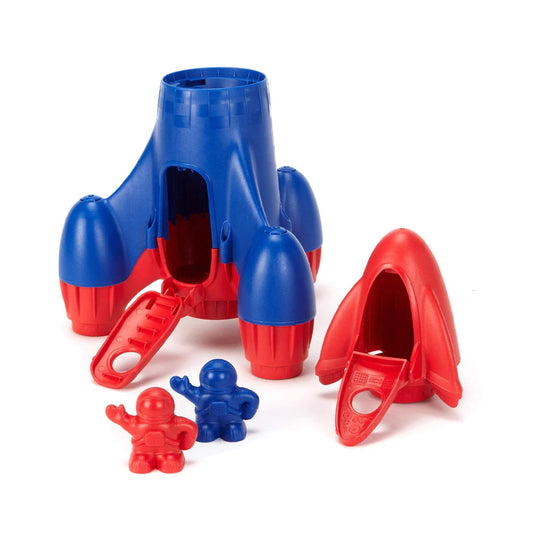 Rocket shown fully opened with the top capsule detached and placed alongside, revealing the interior space and astronaut figures.