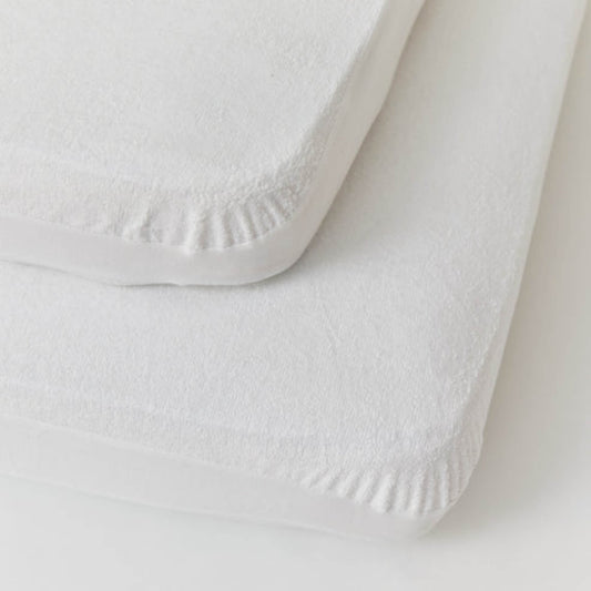 Two stacked white fitted mattress protectors displayed on a flat surface, showing smooth breathable bamboo fabric and deep elasticated edges.