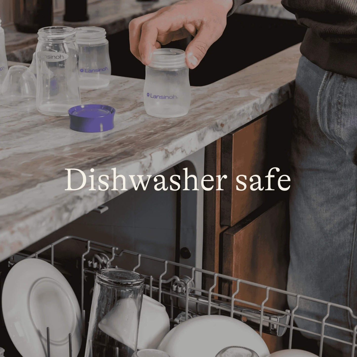Person placing a breastmilk storage bottle beside an open dishwasher with additional bottles and lids shown for dishwasher-safe cleaning.