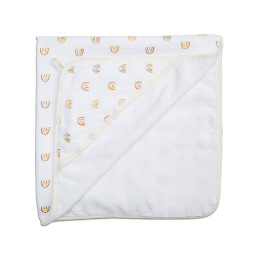 Lulujo Rainbow hooded towel folded flat, displaying the white fabric with delicate gold rainbow arcs printed throughout and soft terry cloth backing for absorbency.