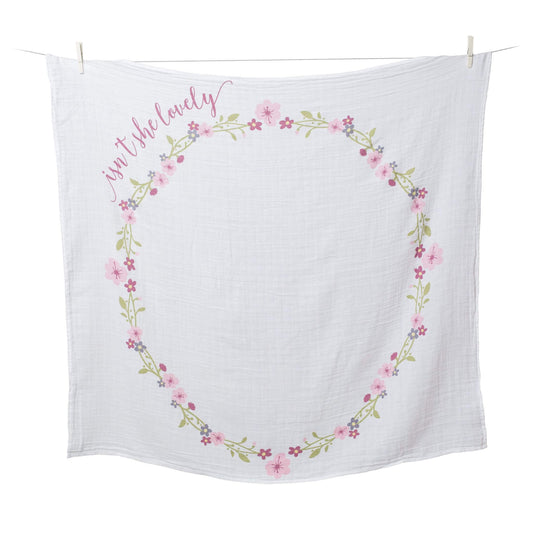 Lulujo "Isn't She Lovely" Milestone Muslin Blanket displayed on washing line showing the beautiful floral wreath design perfect for monthly baby photos.