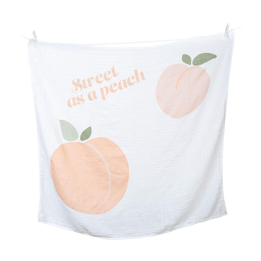 Lulujo white muslin blanket with 'Sweet as a Peach' text and peach illustrations hanging on clothesline, perfect for monthly baby photos.