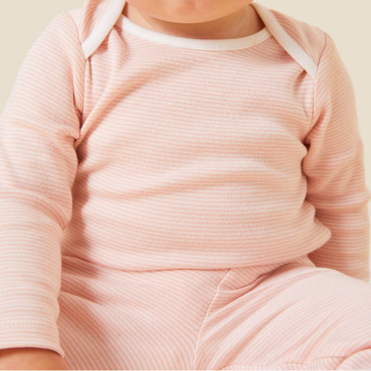 A close view of a baby wearing a blush striped long sleeve bodysuit, showing the fine ribbed fabric texture, envelope neckline and soft pink and white stripes.