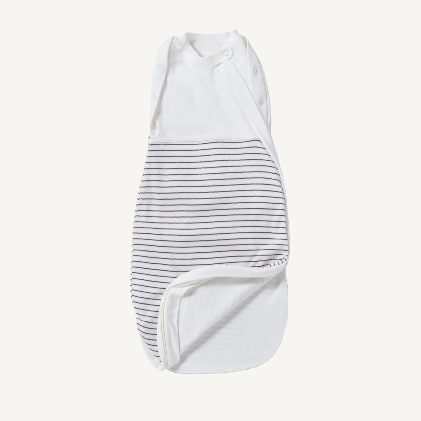 A newborn swaddle bag in grey stripe shown partially unzipped at the bottom, revealing the soft inner lining and wrap-style chest panel with poppers.