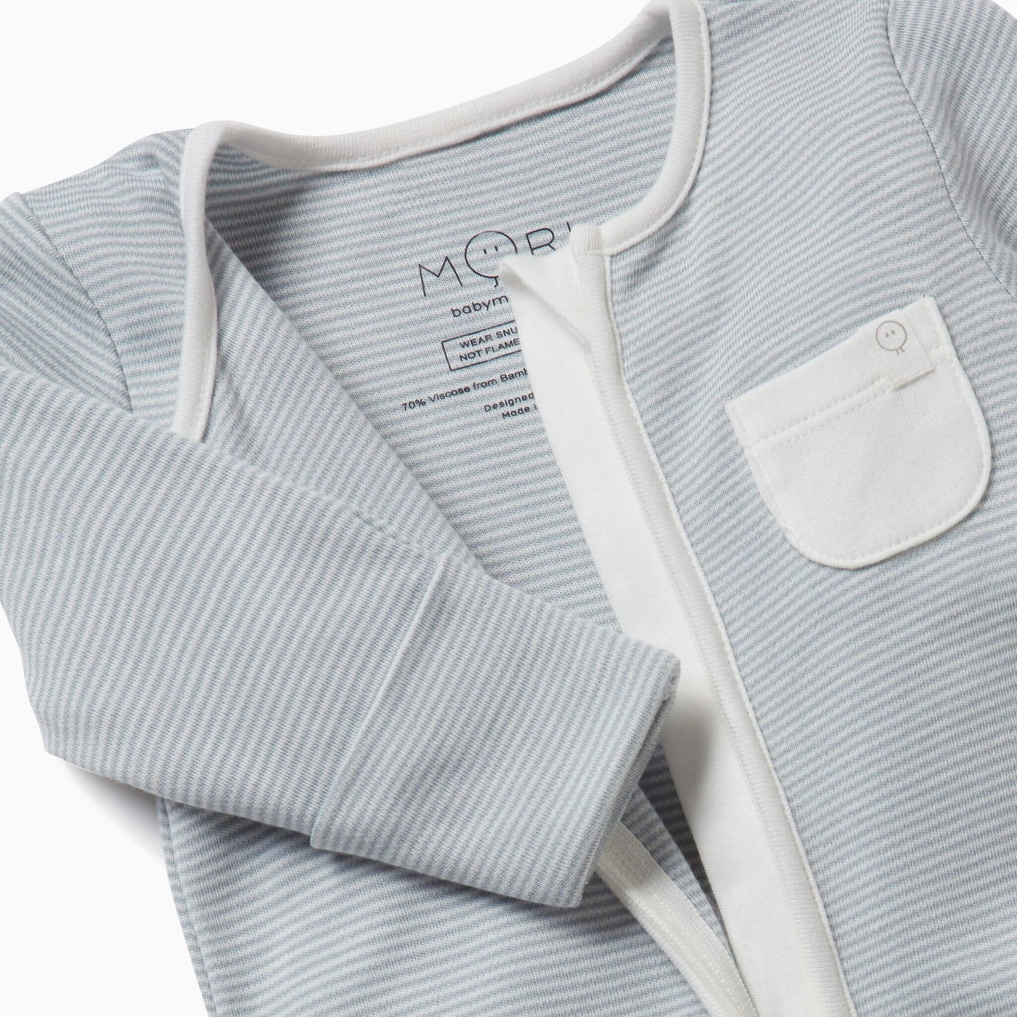 Close-up of a blue striped sleepsuit shown partly unzipped to reveal the inner seams and the soft fabric texture.