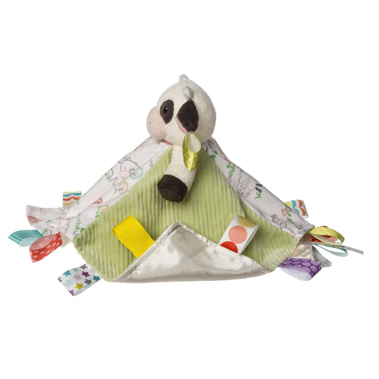 Side view of a baby comfort blanket with a soft cow plush, green corduroy fabric and satin tags in different colours and patterns.