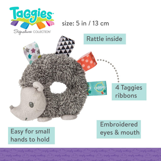 A soft grey hedgehog ring rattle with four colourful Taggies ribbons, embroidered facial features and a gentle rattle inside for sensory play.