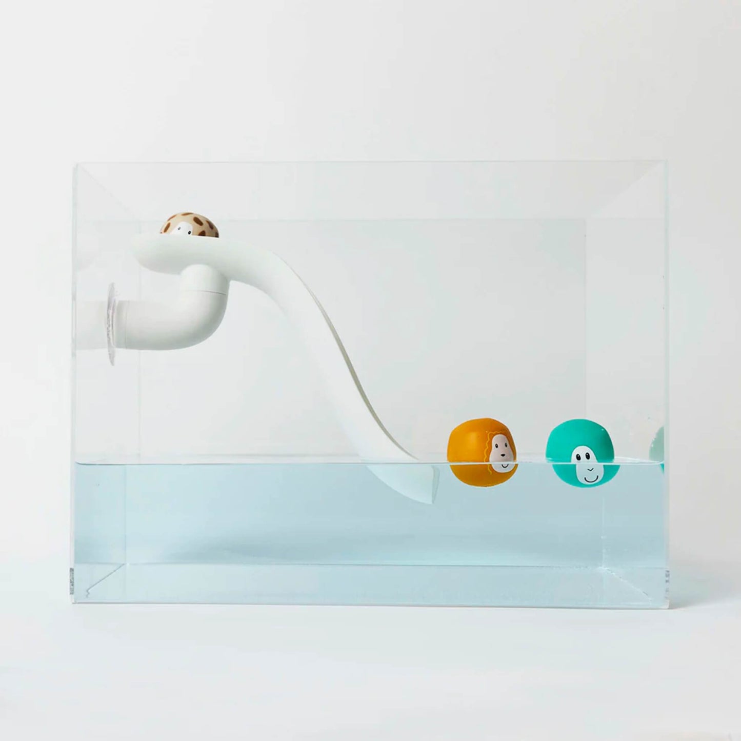 Whit curved slide bath toy positioned inside a clear water tank with three floating animal character balls resting near the slide in the water.