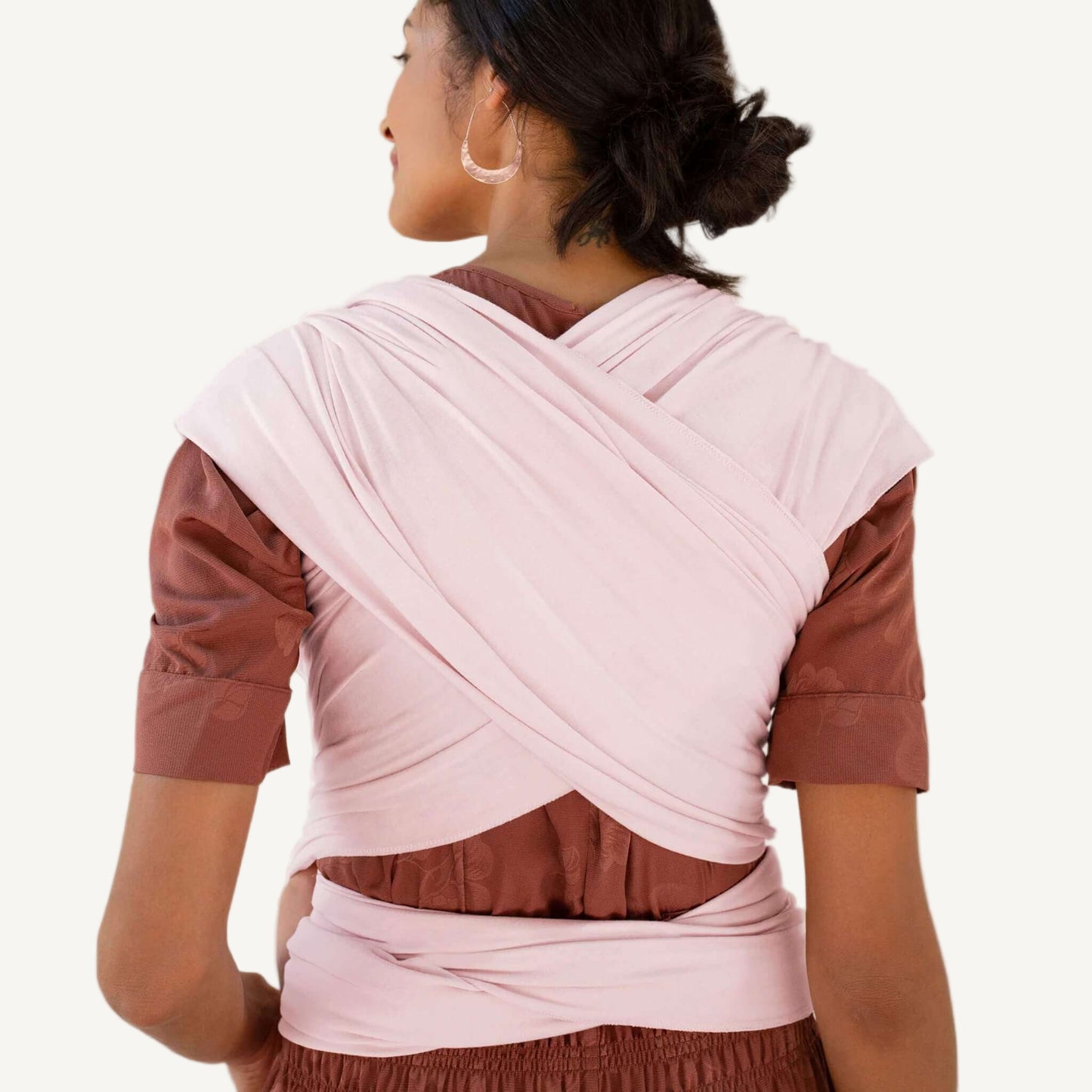 Back view showing the crisscrossed wrap straps and tied ends of a Rose Quartz pink baby wrap