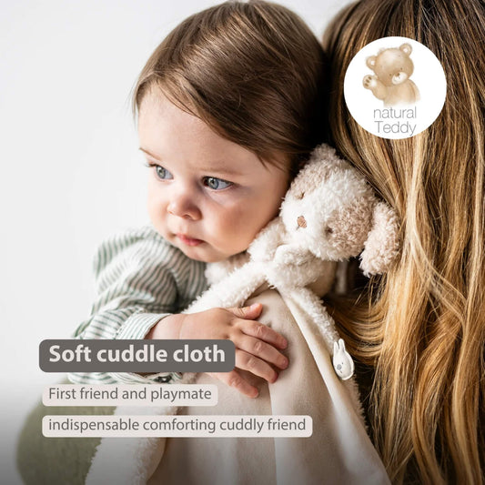 Baby resting against a soft beige comforter with an attached plush dog, shown with the text ‘Soft cuddle cloth’, ‘First friend and playmate’ and ‘indispensable comforting cuddly friend’ on the image.