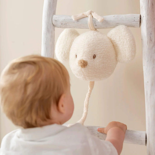Baby reaching for the plush teddy musical mouse, intrigued by its plush texture and gentle music.