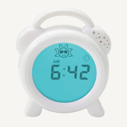 Sleep trainer clock showing blue morning display with AM time, sun icon and digital numbers, indicating wake-up time using blue light technology.