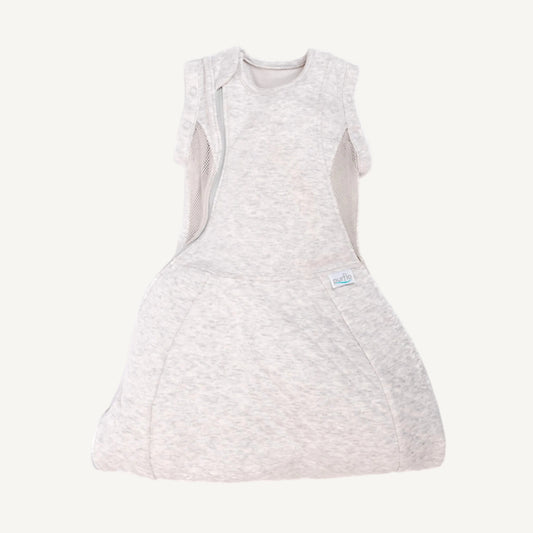 A light grey baby swaddle to sleep bag with breathable mesh side panels, shoulder poppers, and a structured hip-healthy shape laid flat.