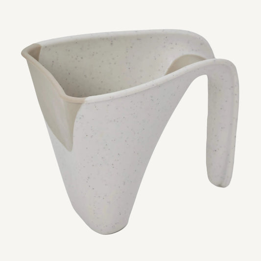 Angled view of a cream jug with curved lip and soft-touch edge designed for pouring water.