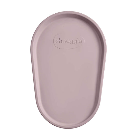 Close-up view of Shnuggle Squishy Changing Mat in blossom colour displaying ergonomic oval design and textured non-slip surface with brand logo.