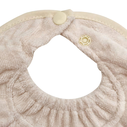 Close-up of Silly Billyz Biblet White Sand. Adjustable double snap closure for a secure and growing fit.