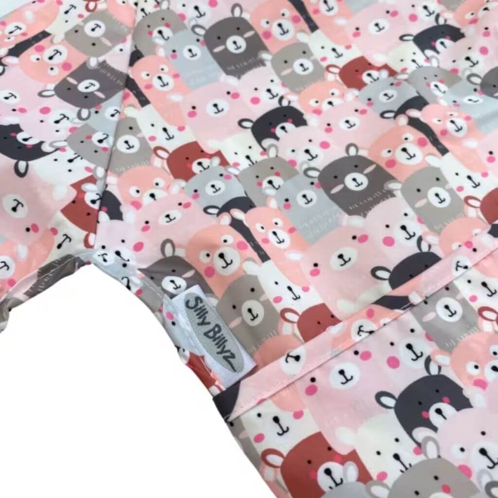 Close-up of the Peekaboo print Silly Billyz long sleeve bib, showcasing wipe-clean, waterproof fabric with secure stitching and branded tag detail.