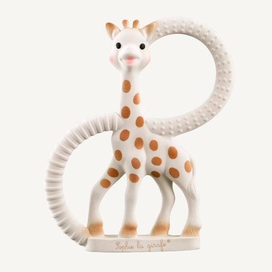 A white natural rubber giraffe-shaped teething ring with two textured circular handles and raised dot details for easy gripping.